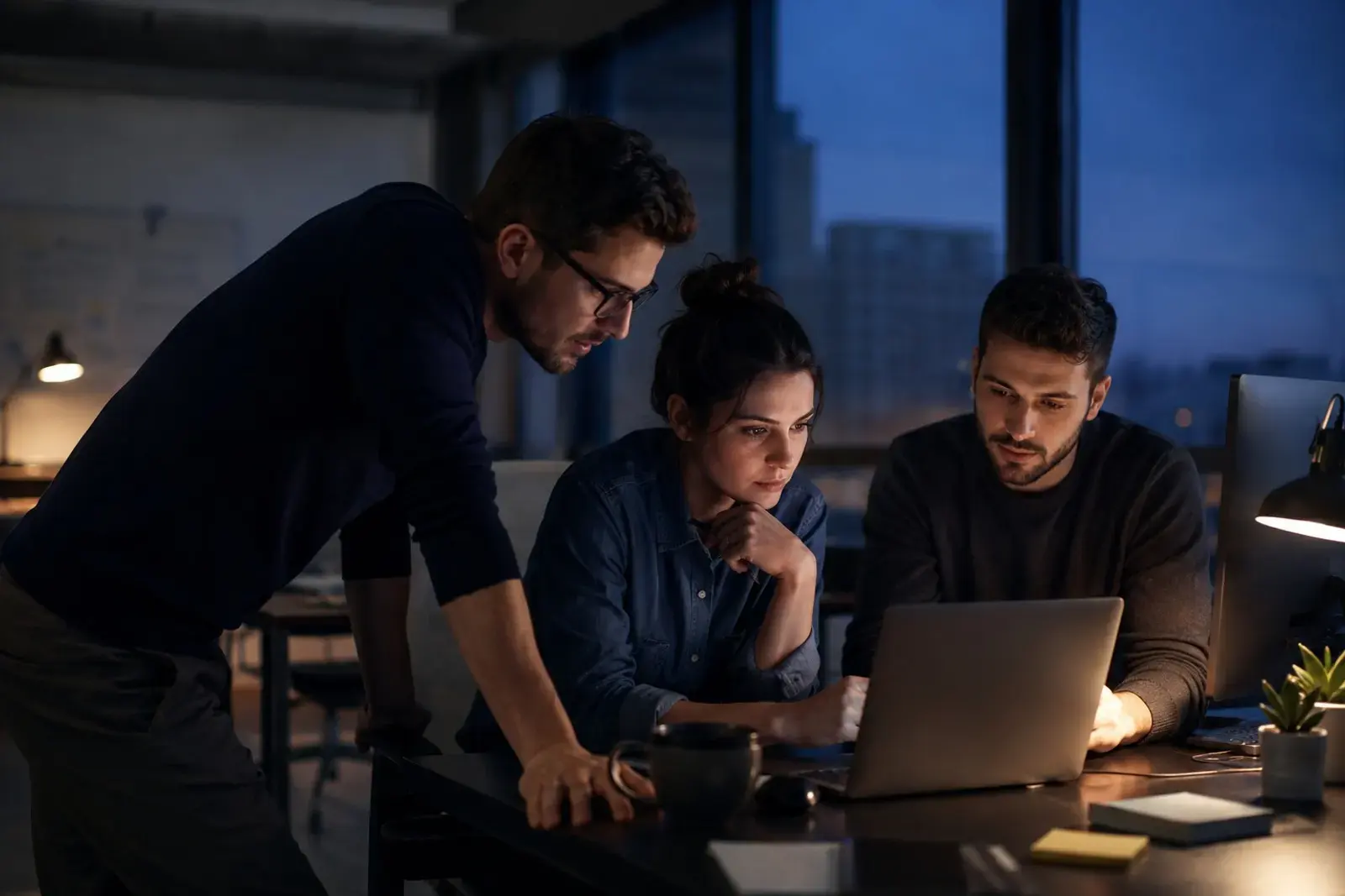 The Encelyte team gathered around a laptop at dusk